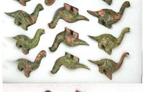 Batch of hand-carved unakite crystal dinosaur figurines in protective foam packaging
