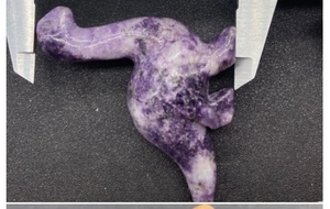Macro shot showing exact width of purple and white natural stone dinosaur carving