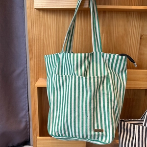 Dettaglio della borsa tote a righe verdi e bianche con etichetta handmade e tasca