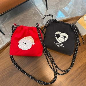 Detalle de los bolsos bandolera de nailon bordados con cordón en rojo y negro