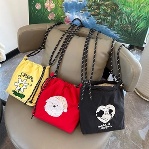 Detalle de bolsos bandolera de lona con cordón en colores amarillo, rojo y negro