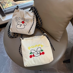 Detalle de bolsos bandolera bordados de nailon con cordón y correa tejida