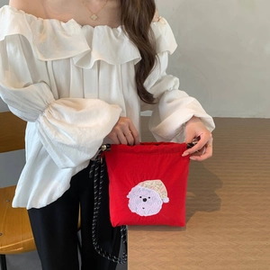 Detalle del bolso de nailon rojo con bordado de perro y correa de cuerda trenzada