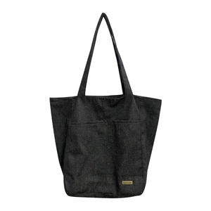 Borsa tote in tela nera con tasca frontale ed etichetta handmade per lo stile casual