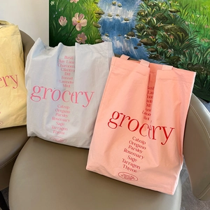 Détail de sacs cabas en toile jaune, bleu et rose avec des imprimés botaniques rouges