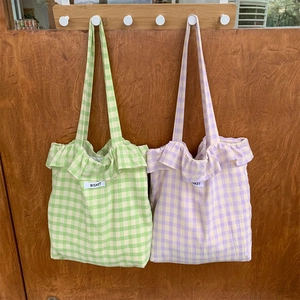 Detail of plaid tote bags with ruffle edges and Bisket label in green and purple