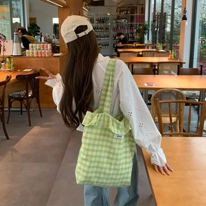 Green and white checkered canvas tote bag with ruffled edges and Bisket label