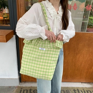Detail of green checkerboard canvas tote bag with ruffled edges and fabric label