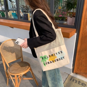 Mesh canvas tote bag featuring tropical sunset print shown on model in urban lifestyle setting