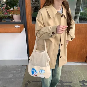 Close-up of khaki trench coat paired with mesh Kuromi cartoon tote bag in street style