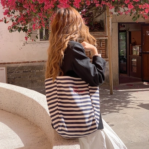 Detail of navy striped canvas tote bag featuring red cat embroidery and Hello text