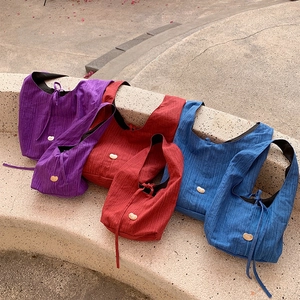 Detail view of vertical texture denim tote bags with gold metal buckle in three colors