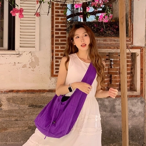 Detailed view of dark purple pleated crossbody bag fabric for versatile daily commuting
