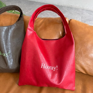 Detail of red and brown soft PU leather tote bags with Hooray! lettering