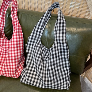 Macro detail of soft black and white plaid canvas tote bag fabric and wide shoulder strap