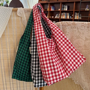 Detailed view of large gingham tote bags in green, black, and red checkered cotton linen