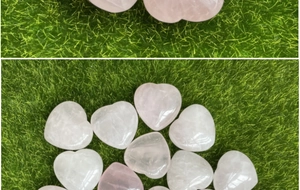 Dettaglio di pietre di quarzo rosa lucido a forma di cuore su sfondo verde erba