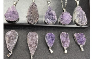 Macro shot of 10-piece raw amethyst crystal pendants with silver-plated metallic edges