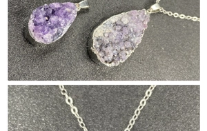 Macro detail of teardrop amethyst druzy pendant with silver plated edge and fine chain necklace