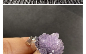 Detailed view of raw purple amethyst cluster pendant with silver plated metal clasp