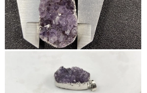 Macro shot of measuring natural amethyst crystal pendant with silver electroplated edge
