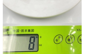 Macro shot of green kitchen scale screen showing 8g and unit mode buttons
