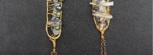 Dettaglio macro di perle barocche irregolari avvolte in un lungo pendente in filo d'oro