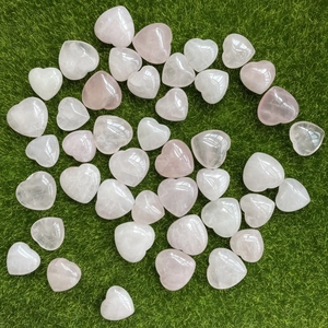Pietre di quarzo rosa a forma di cuore lucido sparse sul prato per decorazione
