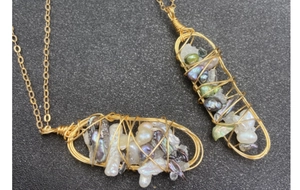 Dettaglio di gabbie avvolte in filo dorato con perle d'acqua dolce barocche colorate