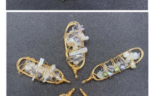 Dettaglio di ciondoli a gabbia in filo dorato fatti a mano con perle barocche e pietre