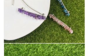 Primo piano dettagliato di tre fermagli per capelli con pietre naturali viola, rosa e blu