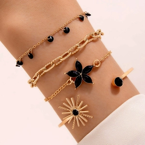 Ensemble de quatre bracelets dorés avec pendentifs fleurs et jonc soleil au poignet