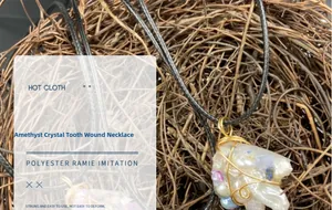 Detail of amethyst crystal pendant with gold wire wrap and decorative pearl accents