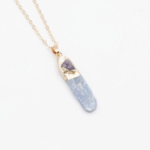 Détail macro du pendentif cyanite bleue avec petit améthyste sur chaîne dorée
