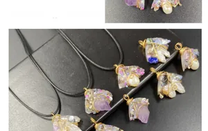 Macro shot of handmade wire-wrapped amethyst and pearl pendants with gold wire