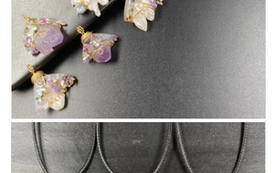 Detailed view of handmade amethyst and pearl wire-wrapped pendant with golden metal craft