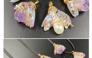 Macro detail of handmade wire-wrapped amethyst, pearl, and abalone shell pendants