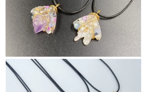 Close-up of wire-wrapped purple amethyst and white stone pendant with gold wire detail