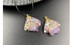 Detailed macro of irregular amethyst stone pendant with handmade gold wire wrap details