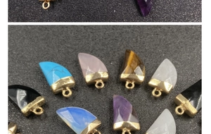 Dettaglio di pendenti a corno in ametista e pietre preziose con bordi placcati oro