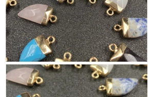 Dettaglio di ciondoli a forma di corno con cappucci placcati in oro in vari colori