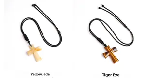 Detailed view of Yellow Jade and Tiger Eye cross pendants with adjustable black cords