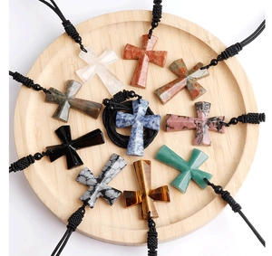 Detail view of ten colorful natural stone cross pendants in a wooden display tray