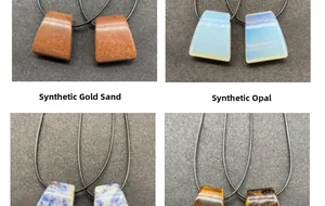 Macro detail of trapezoid agate pendants in goldstone and opal with black cords