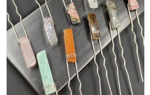 Detail of wire-wrapped natural crystal hair pins featuring amethyst and tiger eye stones