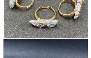 Dettaglio di anelli fatti a mano con filo dorato e cristalli di cianite blu naturale