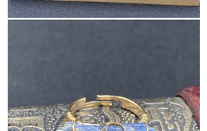 Dettaglio anello artigianale in filo dorato con pietra grezza di cianite blu naturale
