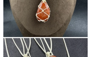 Detailed view of raw red agate stone pendant with handmade woven net and cord