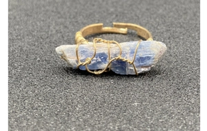 Dettaglio dell'anello regolabile con cianite blu grezza e filo d'oro intrecciato