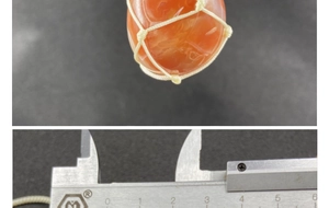 Macro view of red agate raw stone pendant with dimensions measured by caliper